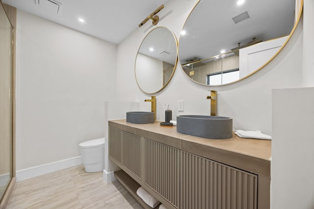 bathroom with visible vents, a sink, and walk in shower