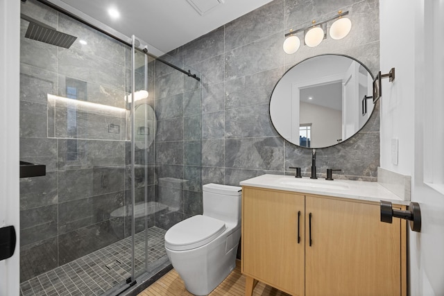 full bath with tile walls, a shower stall, toilet, vanity, and tasteful backsplash