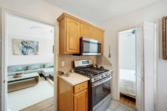 100 Dehaven Dr Unit 612, Yonkers, NY 10703 - kitchen with stainless steel appliances, decorative backsplash, light countertops, light brown cabinetry, and light tile patterned flooring