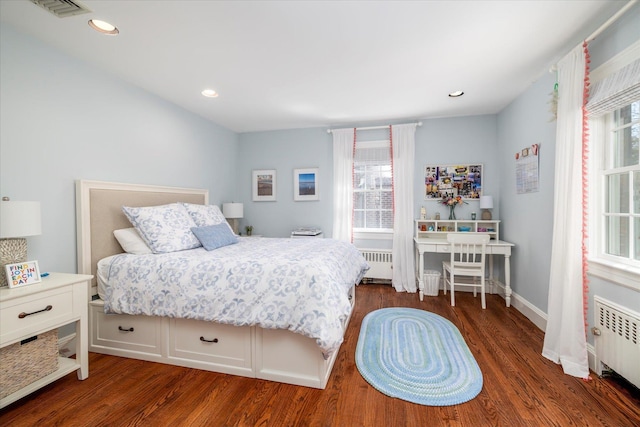 bedroom with radiator, wood finished floors, and visible vents