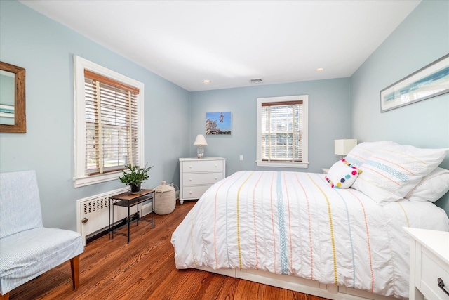 bedroom featuring radiator heating unit, wood finished floors, visible vents, and recessed lighting