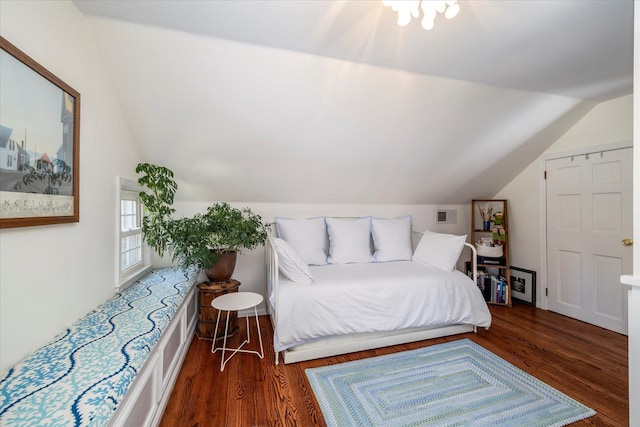 bedroom with lofted ceiling, wood finished floors, and visible vents