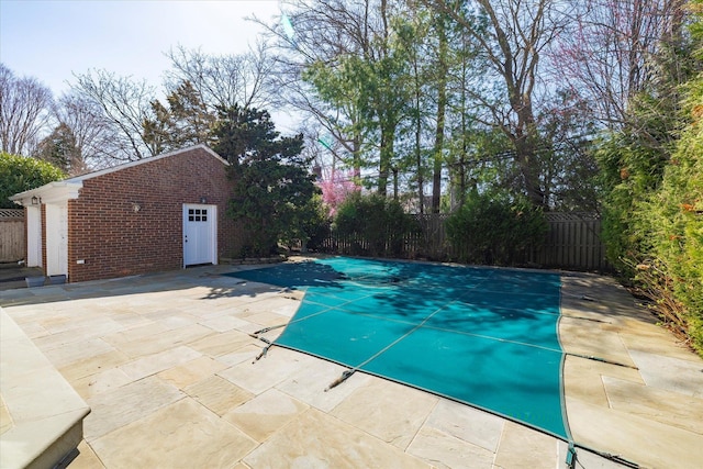 view of pool with a fenced backyard, an outdoor structure, a patio area, and a fenced in pool