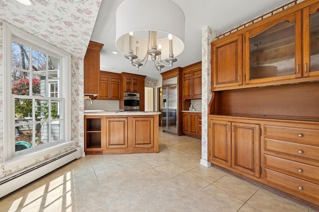 22 Druid Hill Rd, Port Jefferson, NY 11777 - kitchen featuring baseboard heating, appliances with stainless steel finishes, brown cabinets, a chandelier, and wallpapered walls