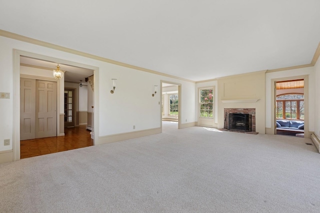 22 Druid Hill Rd, Port Jefferson, NY 11777 - unfurnished living room featuring carpet floors, a fireplace with raised hearth, baseboards, baseboard heating, and crown molding