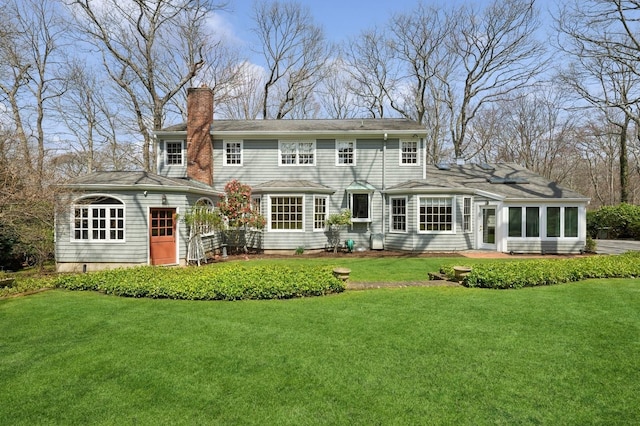 22 Druid Hill Rd, Port Jefferson, NY 11777 - rear view of house with a chimney, a lawn, and a sunroom
