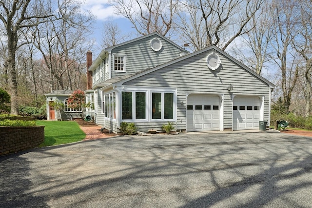 22 Druid Hill Rd, Port Jefferson, NY 11777 - back of house featuring asphalt driveway, a garage, and a chimney