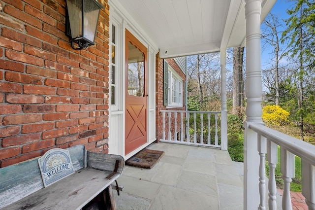 22 Druid Hill Rd, Port Jefferson, NY 11777 - view of exterior entry with a porch and brick siding