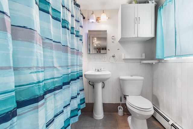 full bathroom with curtained shower, tile patterned floors, toilet, wainscoting, and a baseboard radiator