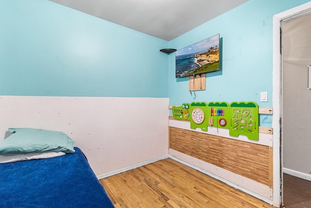 bedroom featuring wood finished floors and baseboards