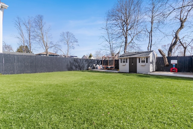 view of yard featuring an outbuilding, a fenced backyard, and a patio