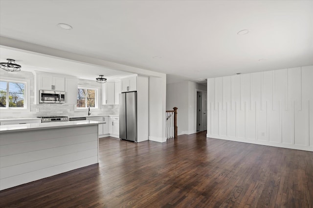 unfurnished living room with dark wood-style floors and a sink