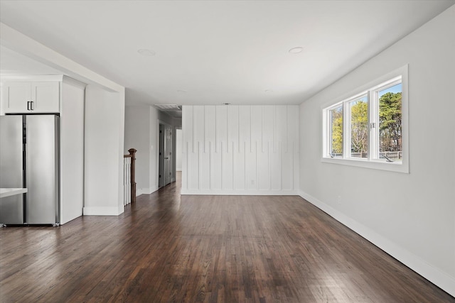 unfurnished living room featuring dark wood finished floors and baseboards