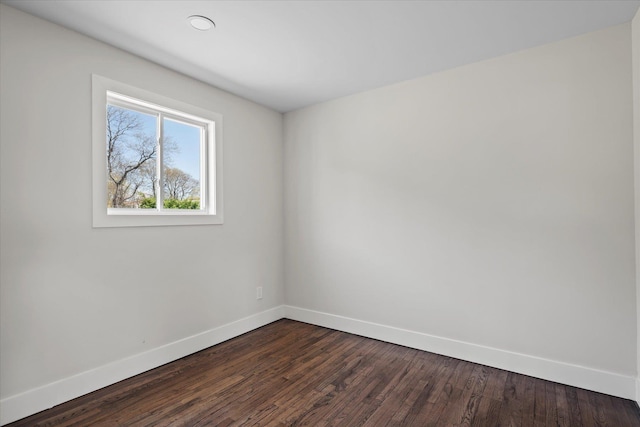 spare room with baseboards, recessed lighting, and dark wood-style floors