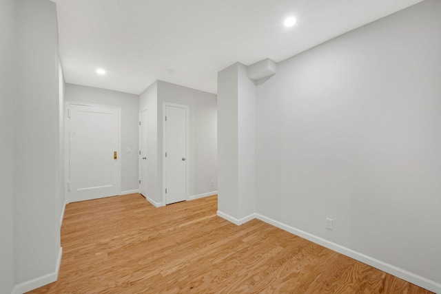 spare room with recessed lighting, baseboards, and light wood-type flooring