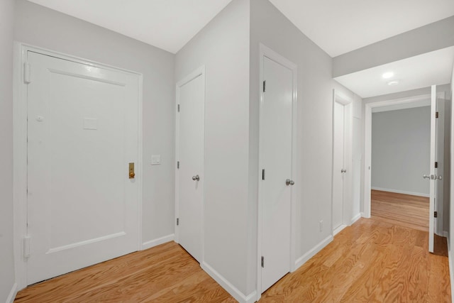 foyer entrance with baseboards and light wood finished floors