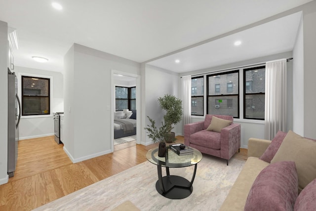 living room with light wood-style floors, recessed lighting, and baseboards