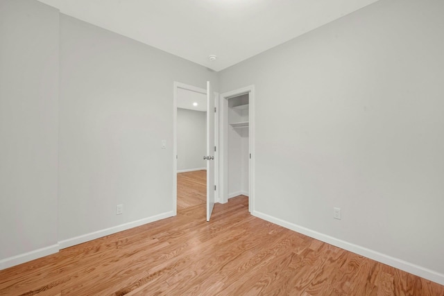 unfurnished bedroom with baseboards and light wood-type flooring