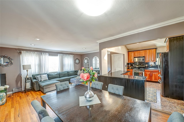 2892 Wilson Ave, Bellmore, NY 11710 - dining room featuring light wood finished floors, baseboards, baseboard heating, and ornamental molding