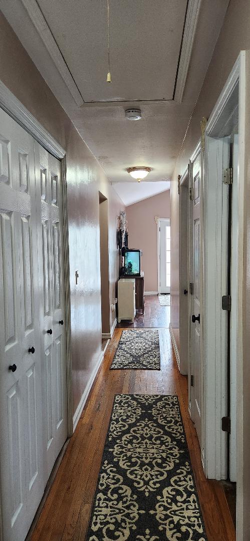 2892 Wilson Ave, Bellmore, NY 11710 - hallway featuring baseboards, lofted ceiling, hardwood / wood-style flooring, and a textured ceiling