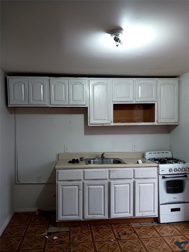 102-23 Russell St, Hamilton Beach, NY 11414 - kitchen featuring baseboards, light countertops, white cabinetry, white range with gas stovetop, and a sink