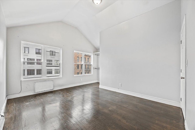 unfurnished room with baseboards, lofted ceiling, and wood finished floors