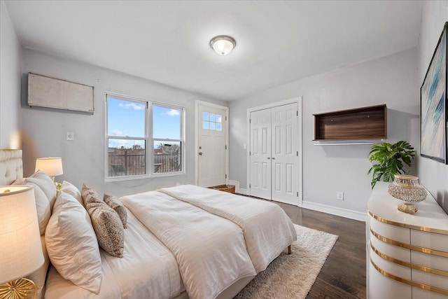bedroom with baseboards, a closet, and dark wood-style flooring