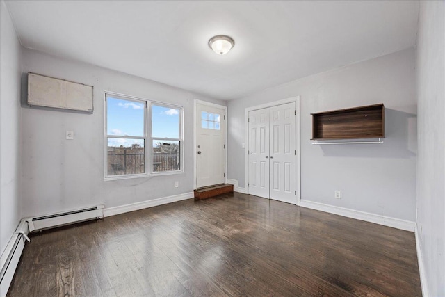 foyer entrance featuring baseboards, wood finished floors, and a baseboard heating unit