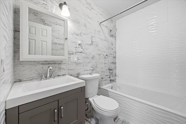 full bathroom featuring tile walls, toilet, vanity, and washtub / shower combination