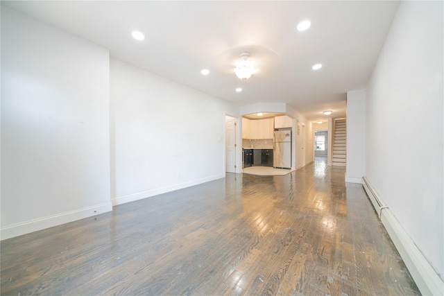 unfurnished living room with baseboards, a baseboard heating unit, recessed lighting, and dark wood finished floors