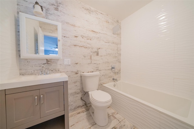 bathroom featuring toilet, vanity, and shower / tub combination
