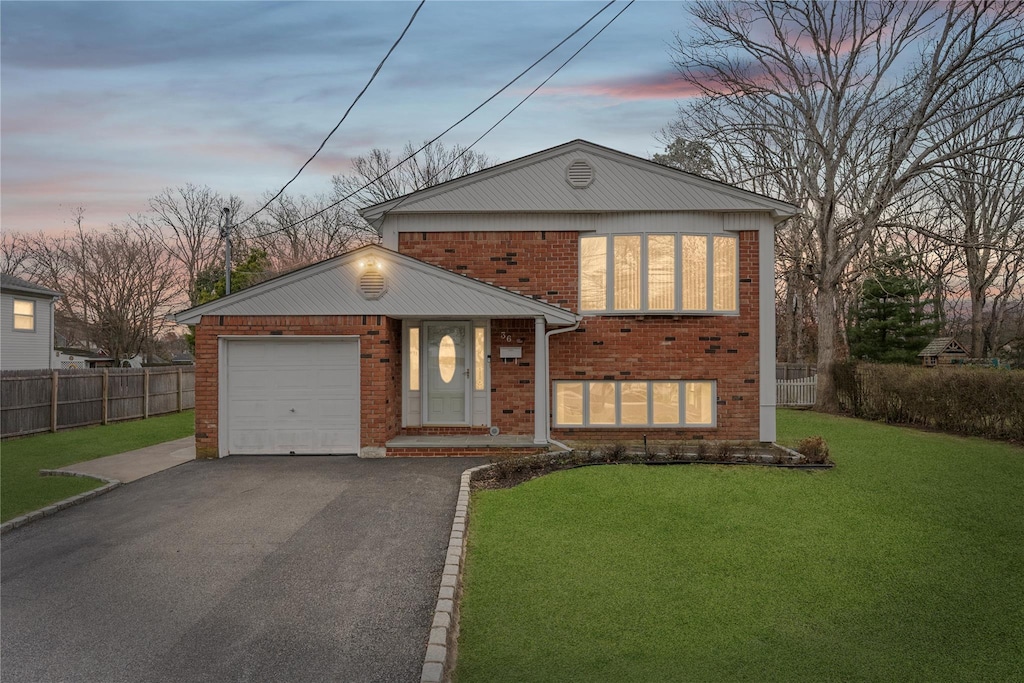 36 E Belmont St, Bay Shore, NY 11706 - view of front of property with fence, driveway, a front yard, brick siding, and a garage