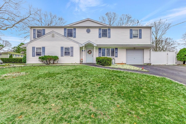 view of front facade with a gate, an attached garage, fence, aphalt driveway, and a front lawn