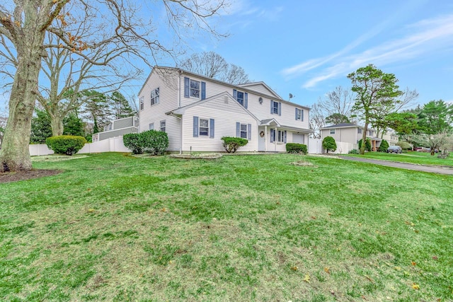 view of front of property featuring aphalt driveway, fence, a front lawn, and a garage