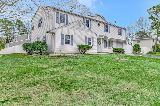 view of front of house with an attached garage, fence, and a front lawn