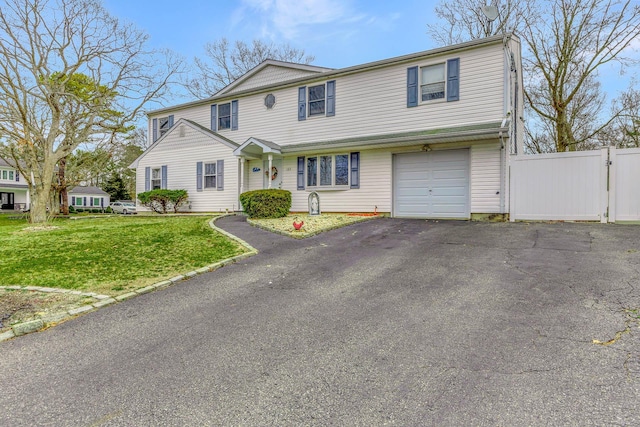 view of front of house featuring fence, an attached garage, aphalt driveway, a gate, and a front lawn