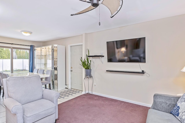 carpeted living area featuring baseboards and ceiling fan
