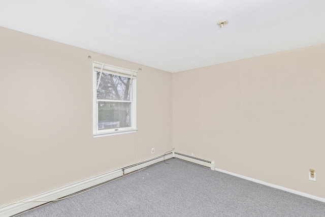 spare room featuring carpet flooring, baseboards, and a baseboard heating unit
