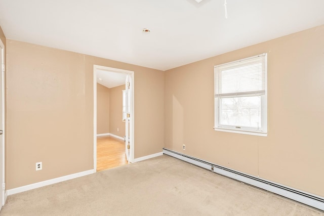 carpeted empty room featuring baseboards and a baseboard heating unit