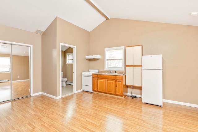 kitchen featuring a sink, lofted ceiling with beams, light wood-style floors, and white appliances