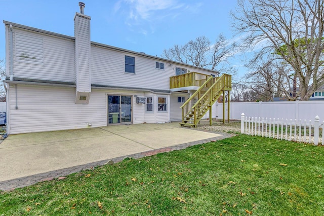 back of property with stairs, a patio area, a chimney, fence, and a yard