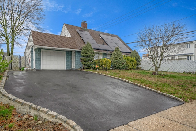 173 Bloomingdale Rd, Levittown, NY 11756 - view of front of property featuring roof mounted solar panels, aphalt driveway, a garage, fence, and a shingled roof