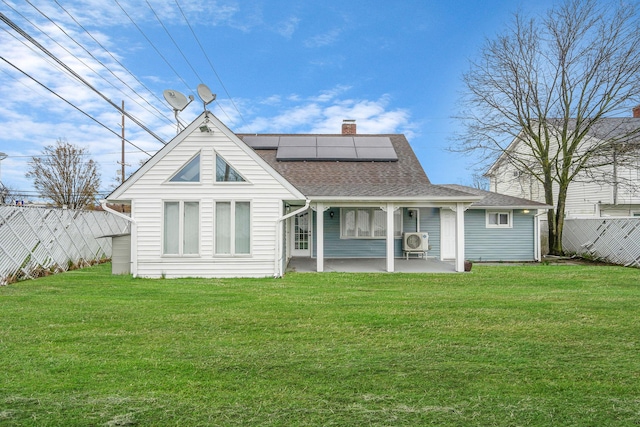 173 Bloomingdale Rd, Levittown, NY 11756 - back of property with a yard, solar panels, a shingled roof, and a patio