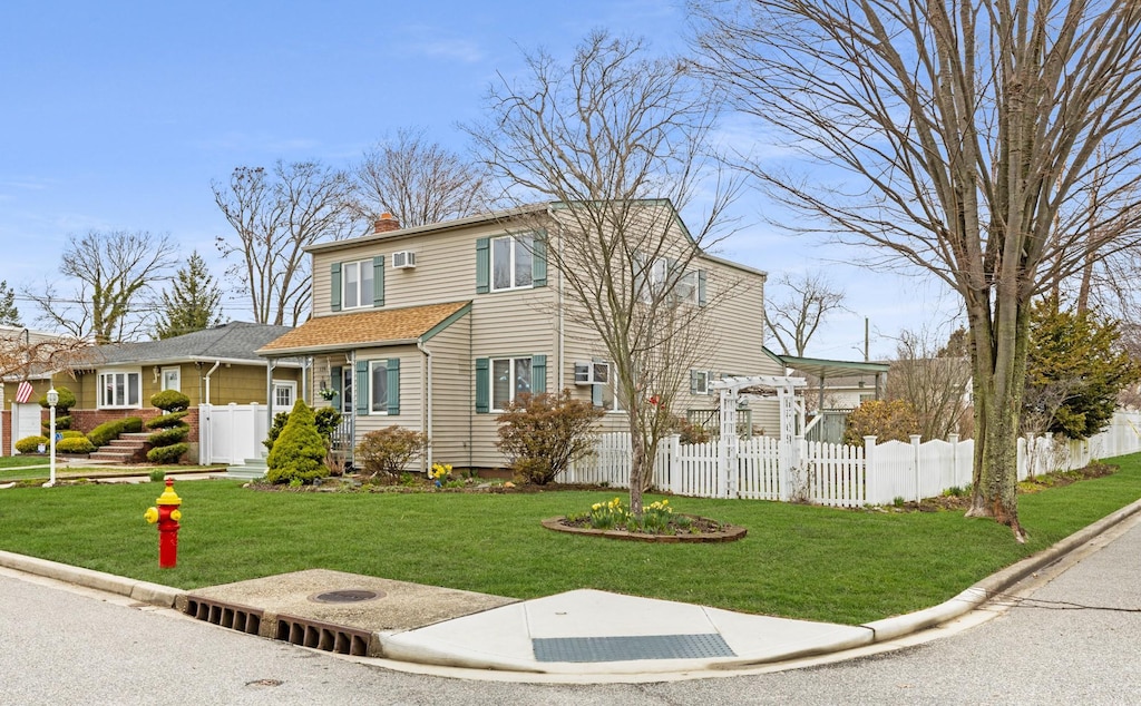 view of front of home with a pergola, a chimney, a front yard, and fence