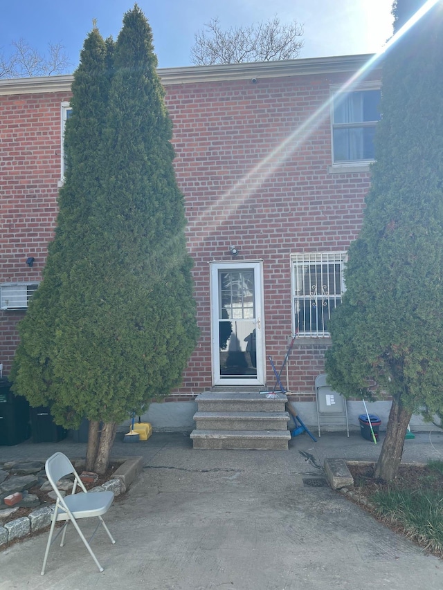 2443 Bouck Ave, Bronx, NY 10469 - rear view of house with brick siding, a patio area, and entry steps