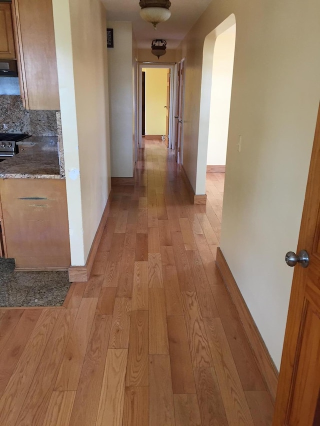 2443 Bouck Ave, Bronx, NY 10469 - corridor with light wood-style flooring, arched walkways, and baseboards