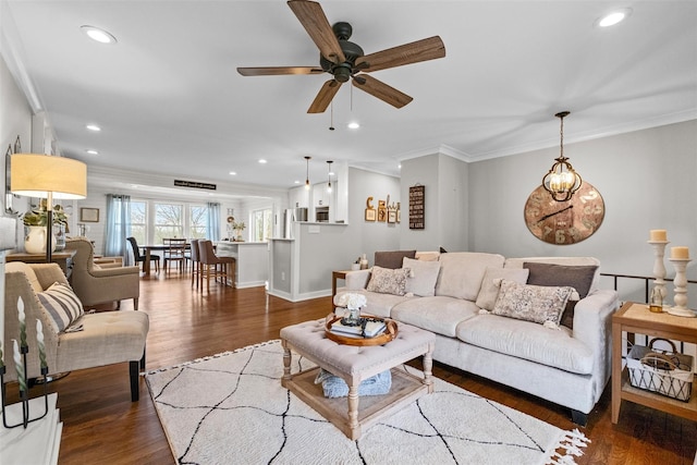 living area with recessed lighting, wood finished floors, a ceiling fan, and ornamental molding
