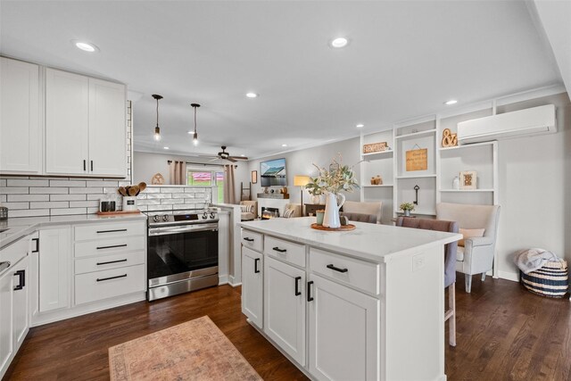kitchen featuring a wall unit AC, dark wood-style flooring, tasteful backsplash, electric range, and a ceiling fan