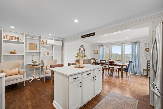 kitchen featuring freestanding refrigerator, a wall mounted AC, and dark wood-style floors