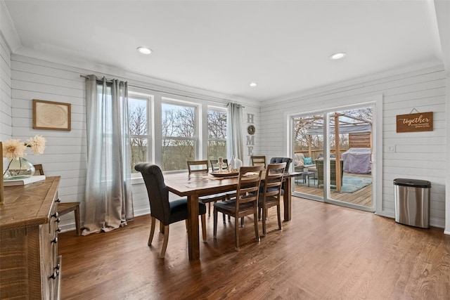 dining room featuring wooden walls, wood finished floors, and recessed lighting